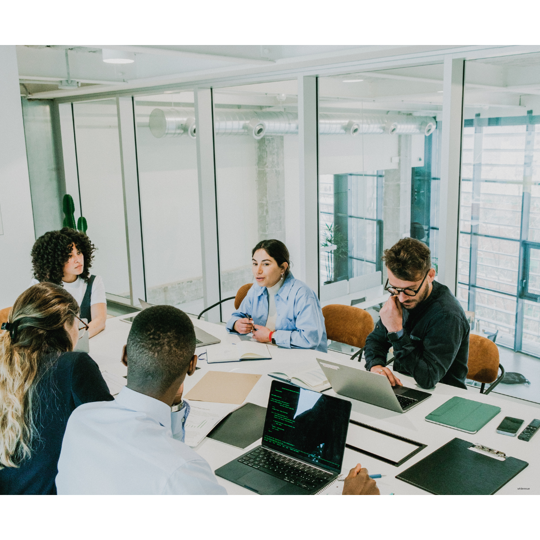 Team of recruiters analyzing passive candidate profiles on laptops in a modern meeting room